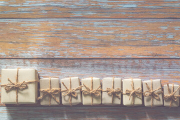 Two boxes in eco paper on the wooden table. Top view. Parcels or gifts tied with twine.