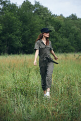 Naklejka na ściany i meble Woman in the meadow Green suit black cap fresh air freedom 