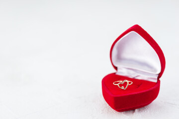 Gold ring in the form of a heart in a red box. Valentine's Day. Wedding, engagement.