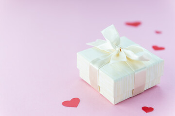 Gift box with hearts on a pink background. Horizontal orientation, copy space.