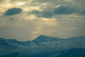 Fototapeta premium View of the highest peaks of Sierra Nevada (Granada, Spain) on a cloudy winter morning at sunrise