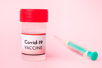 Covid-19 vaccine in the bottle and disposable syringe for injection on the pink background. Prevention of coronavirus, Sars-Cov-2.