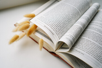 an open book with curled pages and a bouquet of dried flowers