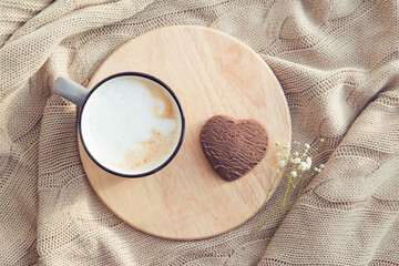 cappuccino cup and heart shape chocolate cookie, breakfast in bed for valentine, flat lay