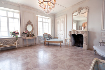 Luxurious light interior of the living room in the baroque style as in a royal castle with old stylish vintage furniture, columns, stucco on the walls
