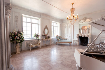 Luxurious light interior of the living room in the baroque style as in a royal castle with old stylish vintage furniture, columns, stucco on the walls