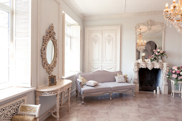 Luxurious light interior of the living room in the baroque style as in a royal castle with old stylish vintage furniture, columns, stucco on the walls