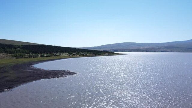 Aerial Drone shot of Mountain Lake with slow passing shore