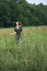 Naklejka na ściany i meble Woman in the meadow Tickets in green jumpsuit fresh air outdoor activities 