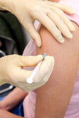 Eine Patientin erhält eine Impfdosis in die Schulter - Coronaimpfung