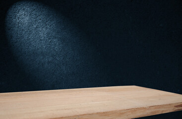 image of a wooden table on an abstract dark background with light in the center