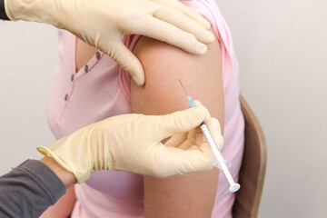 Eine Patientin erhält eine Impfdosis in die Schulter - Coronaimpfung