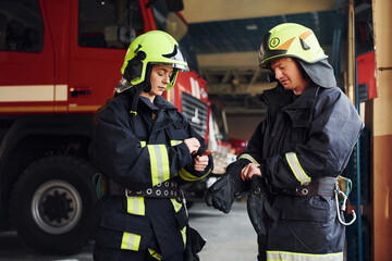 Male and female firefighters in protective uniform standing together