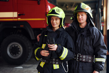 Obraz premium Male and female firefighters in protective uniform standing together