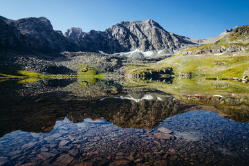 Mountains are reflected in the clear transparent water of a mountain lake