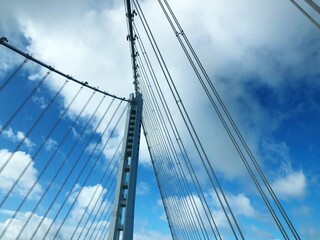 Obraz na płótnie Canvas Low Angle View Of Suspension Bridge Against Cloudy Sky