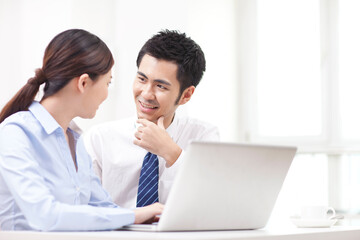 Businessman and businesswoman discussing working on computer
