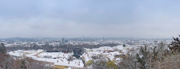 Fototapeta premium Cityscape of Graz with Church of the Sacred Heart of Jesus and historic buildings rooftops with snow, in Graz, Styria region, Austria, in winter