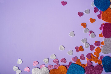 Hearts, arrangement with several colored EVA hearts on a lilac leaf, selective focus, top view.