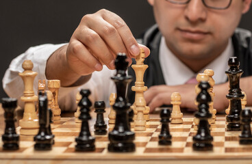 Man playing on fine wooden chess board.
