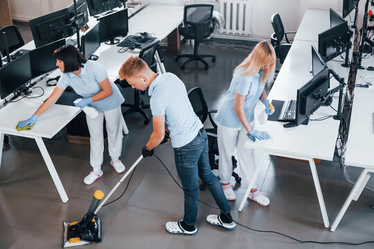 Concentrated at job. Group of workers clean modern office together at daytime - two people cleaning 