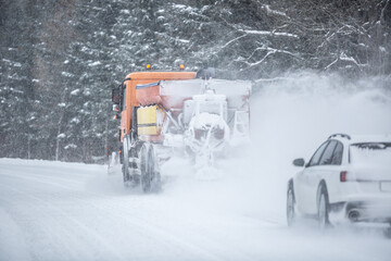 Poor road visibility of a car driving right behind a snow plow during winter road maintenance