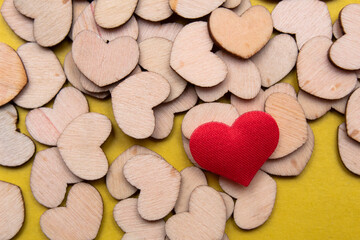 Obraz premium Macro view of wooden and red hearts on yellow background.