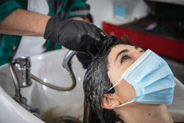 hairdresser stylist washing hair to woman in sink