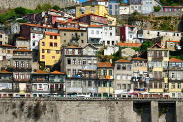 Fototapeta na wymiar Colorful facades of old houses with clothes hanging on a rope on the banks of the Douro River in Porto.