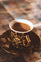 Vertical photo of strong black eastern coffee. Selective focus, blurred background.