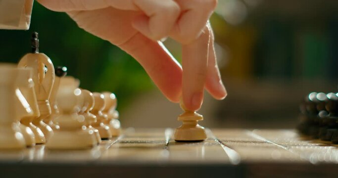 Close up to Wooden Chess Game with Gambit Opening. Players start to move pieces on chessboard with pawns. Sport and Hobby at Lockdown. 4K Cinematic Macro Pan Shot in Slow Motion