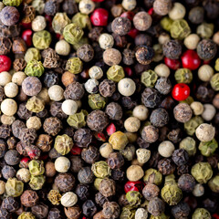 Assorted peppers.A mixture of peppers.Various sharp stoves.Mix of dry round hot red pepper, black pepper, white pepper, green pepper, background.Background for the kitchen.Background from peppercorns.