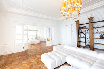 modern interior of a luxurious large bright two-room apartment. white walls, luxurious expensive furniture, parquet flooring and white interior doors