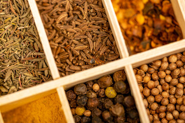 A set of different spices in a wooden box. Close-up, selective focus.