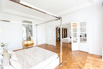 modern interior of a luxurious large bright two-room apartment. white walls, luxurious expensive furniture, parquet flooring and white interior doors