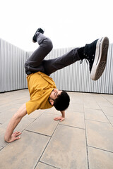 Caucasian white guy with beard dancing break dance underground hip hop with gray sweatshirt and...