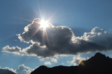 Sonne strahlt hinter dunklen Wolken hervor