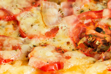 Fresh pizza with bacon, tomatoes, cheese and mushrooms, close-up.