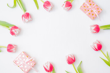 Flat lay valentines day frame with pink tulips and gift box on a white background