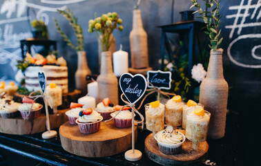 sweet cakes, cupcakes, sweet table, treat. serving the table with sweets, cakes, confectionery. wedding cake, garland of light bulbs, holiday atmosphere, coziness