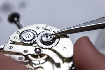 Closeup shot of a craftsman fixing gears on a clock