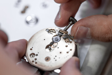 Closeup shot of a watchmaker fixing the gear on a watch
