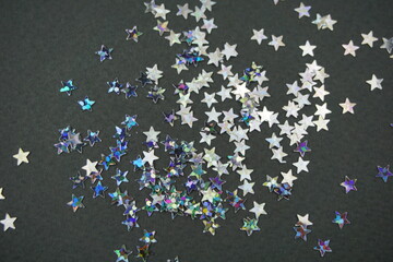 Silver decorative stars on gray background. Selective focus.