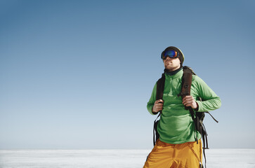 Young adult man with backpack outdoors exploring icy landscape