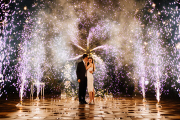 bride and groom are standing in the hallway of the fountains of the fireworks
