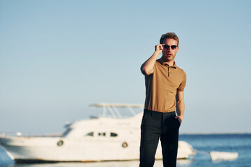 In sunglasses. Young man is outdoors at sunny daytime. Concept of vacation