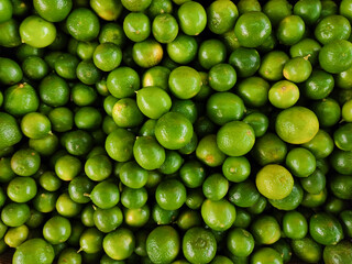 Pile of green lemons on the market