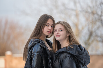 Portrait of two charming young girls, outdoors, close up