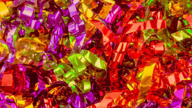 Abstract background close up colorful holiday metal ribbons.Foil serpentin of firecrackers.Red,orange,yellow,pink,purple,golden celebration tapes.Concept of congratulation,festive event,fun.Copy space