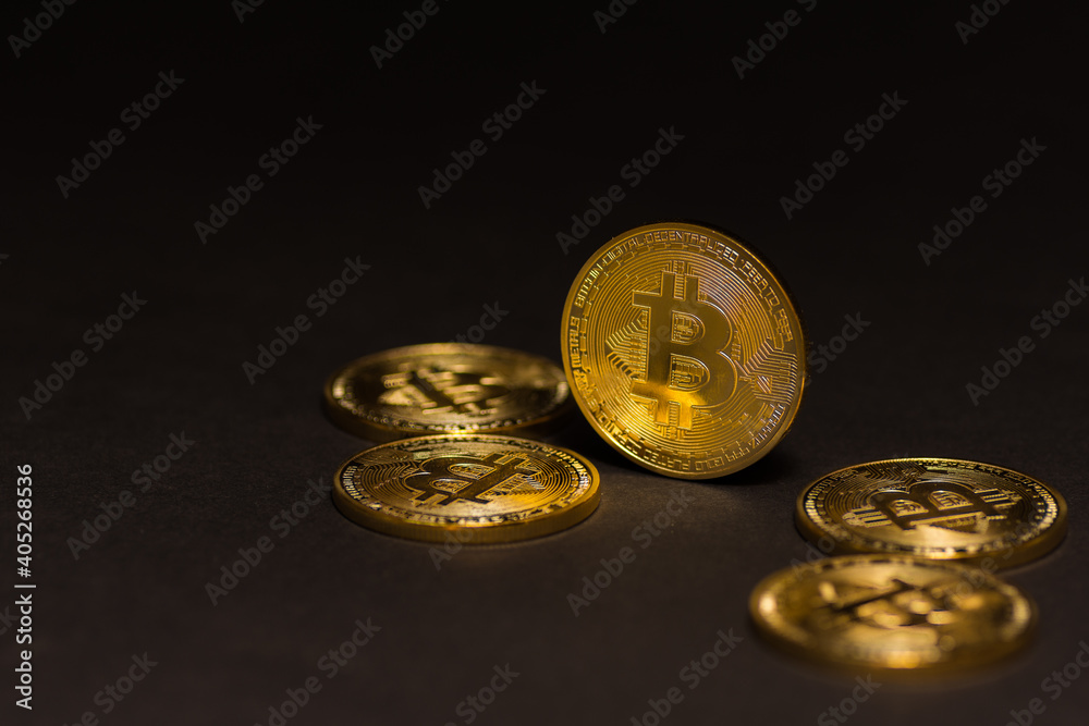 Wall mural golden shiny expensive bitcoins lying on black background right